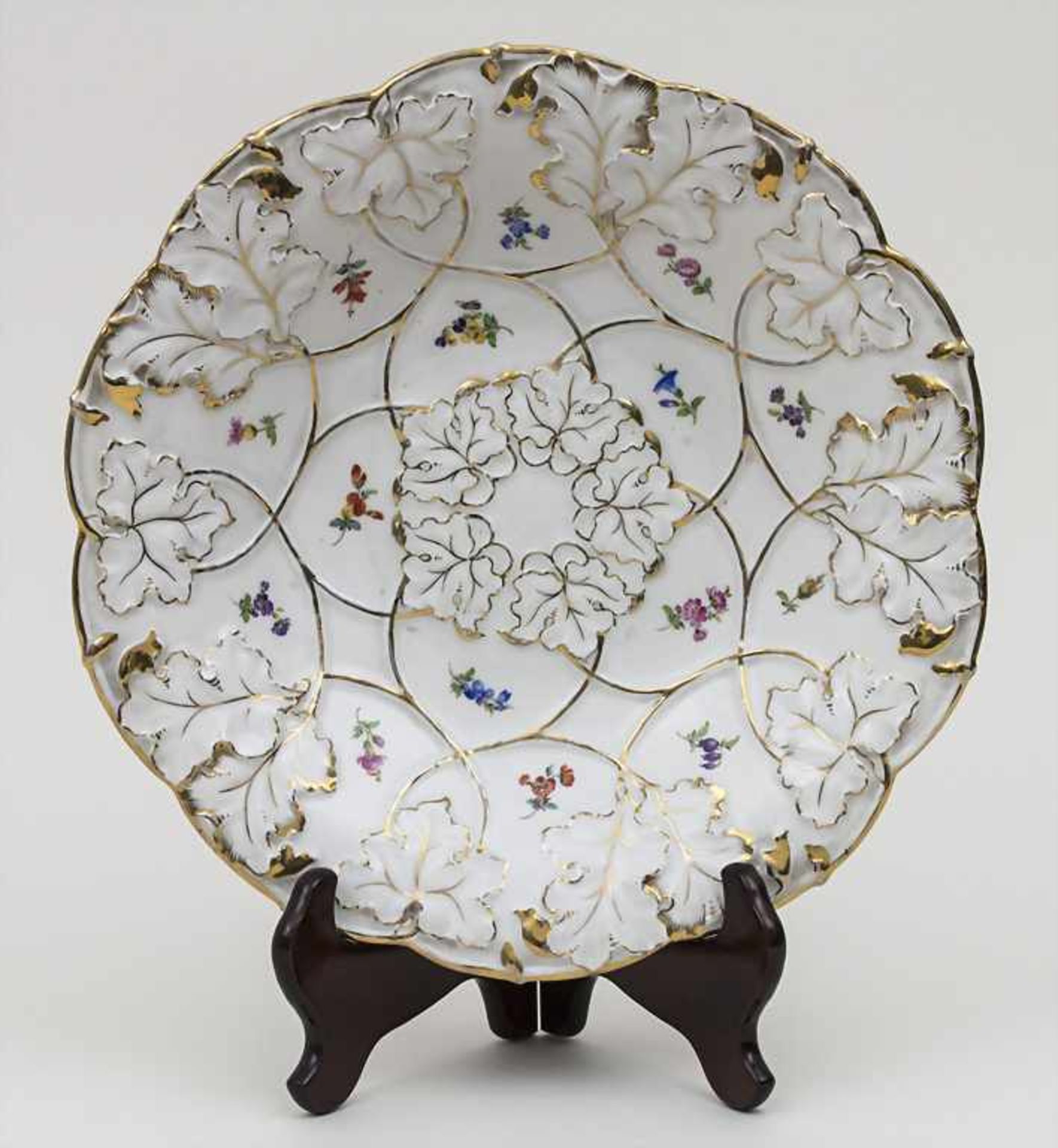 Prunkteller mit Streublumen und goldstaffiertem Blattrelief / A plate with scattered flowers,