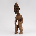 Hockende Figur mit Kalebassen in den Händen. Bamun/Kamerun, Holz mit Erdkrustation. Große Figur