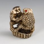 Ungewöhnliche Netsuke. Wohl Elfenbein, signiert, um 1900. Auf einem Bastkorb mit Früchten