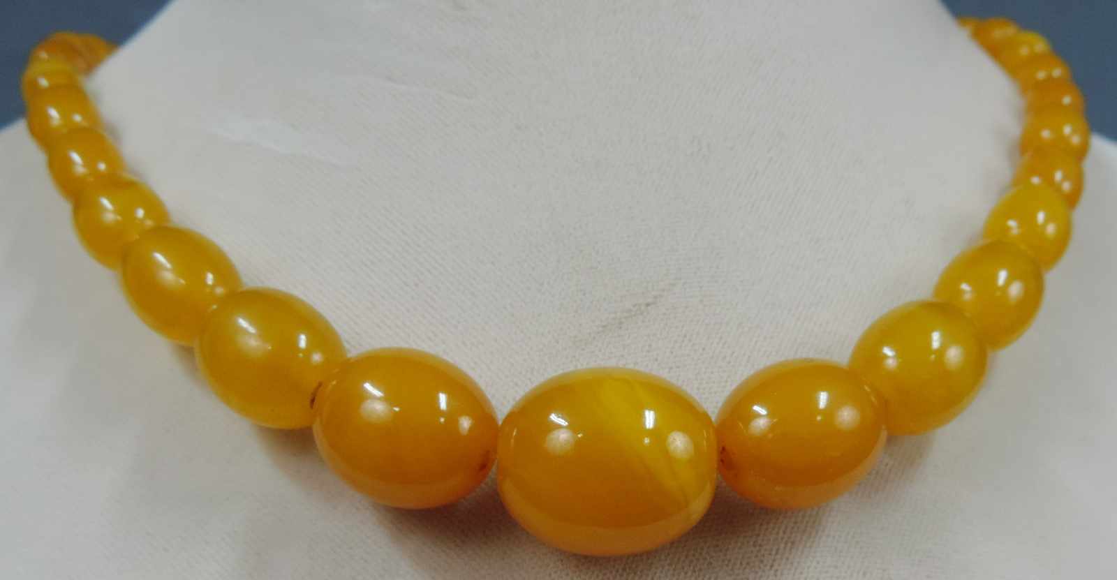 Kette. Bernstein? Olivenform. Wohl Bakalit. Bis 20 mm. Chain. Amber? Olive shape. Probably bakelite.