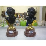 A pair of late 19th century French bronze busts of laughing putti, after Clodion, each on gilt socle