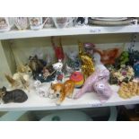 A shelf of animal figurines including glass swans and fish, ceramic cats, dogs and frogs and a