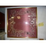 A framed beadwork sample panel with a decorative floral design on claret coloured satin, from the