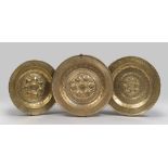 THREE BRASS ALMONERS, 18TH-19TH CENTURY embossed motif of fruit and adorned Carthusians. Diameters