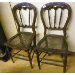 A PAIR OF CHAIRS, 19TH CENTURY walnut, with a sweetheart back with Tunnel railing. Seats in cane,