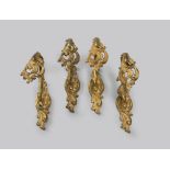 FOUR GILDED BRONZE TIEBACKS, 19TH CENTURY with ramages and decorums to leaves. Measures cm. 20 x 7 x