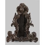 CARVED WOOD MIRROR, PROBABLY NAPLES, EARLY 18TH CENTURY to brown lacquer, with heads of cherubs on