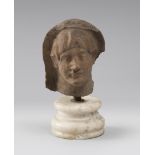 A VOTIVE MALE HEAD, 4TH, 1ST CENTURY B.C. Brown earthenware. Oval face, well-defined eyes, very