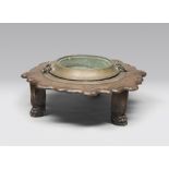 Low table with brazier, brass tub and iron handles, ancient elements.