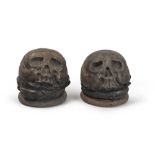 A pair of sculptures marble of skull and crossbones with iron ring sideburns, Medieval period.