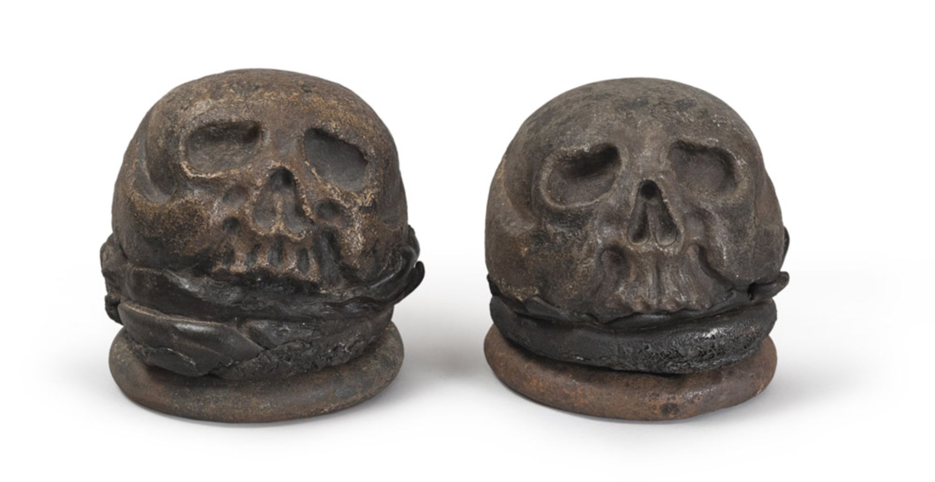 A pair of sculptures marble of skull and crossbones with iron ring sideburns, Medieval period.