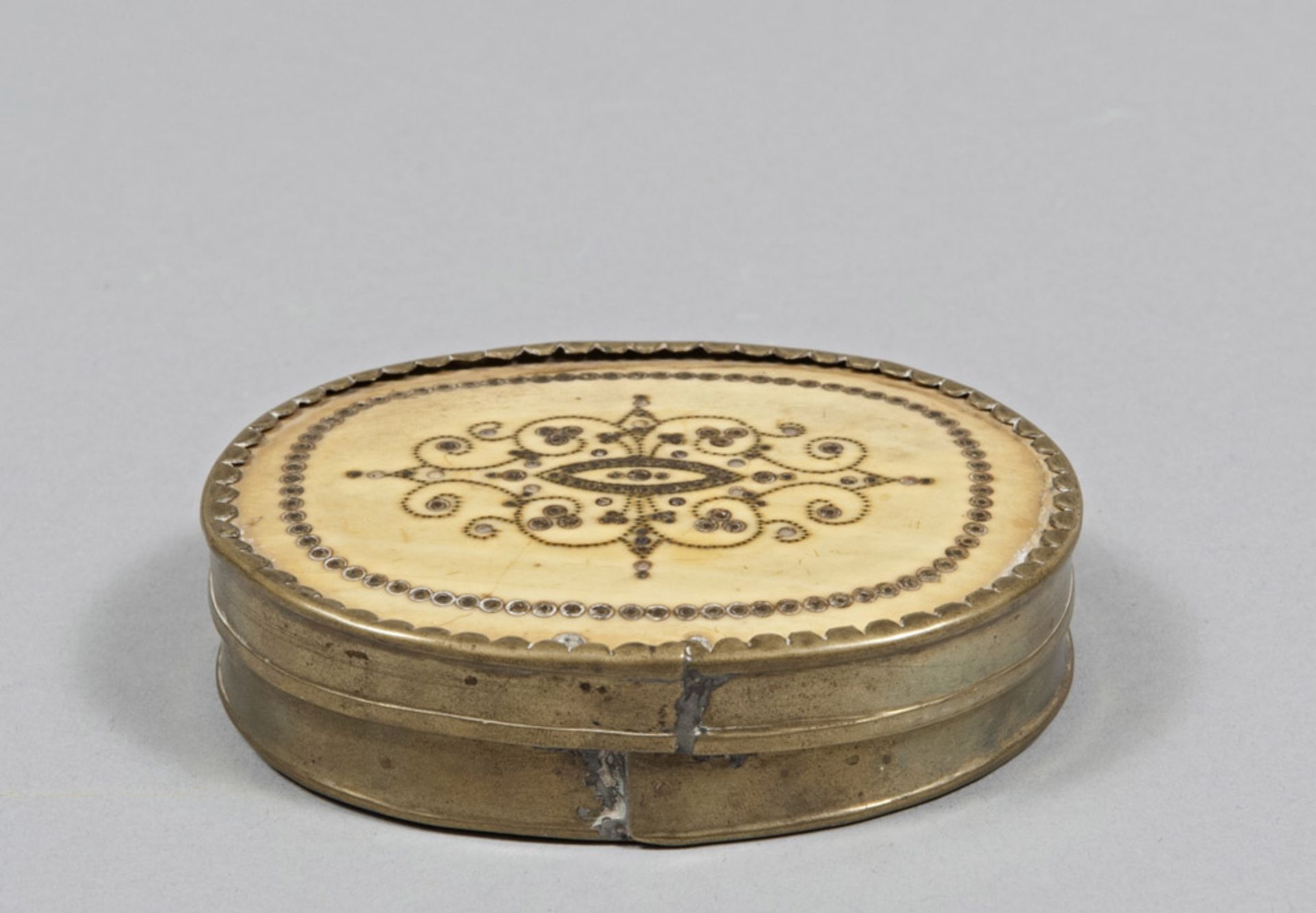 BRASS AND BONE OVAL BOX, 19TH CENTURY cover damascened with plant motifs. Measures cm. 3 x 10 x 8.