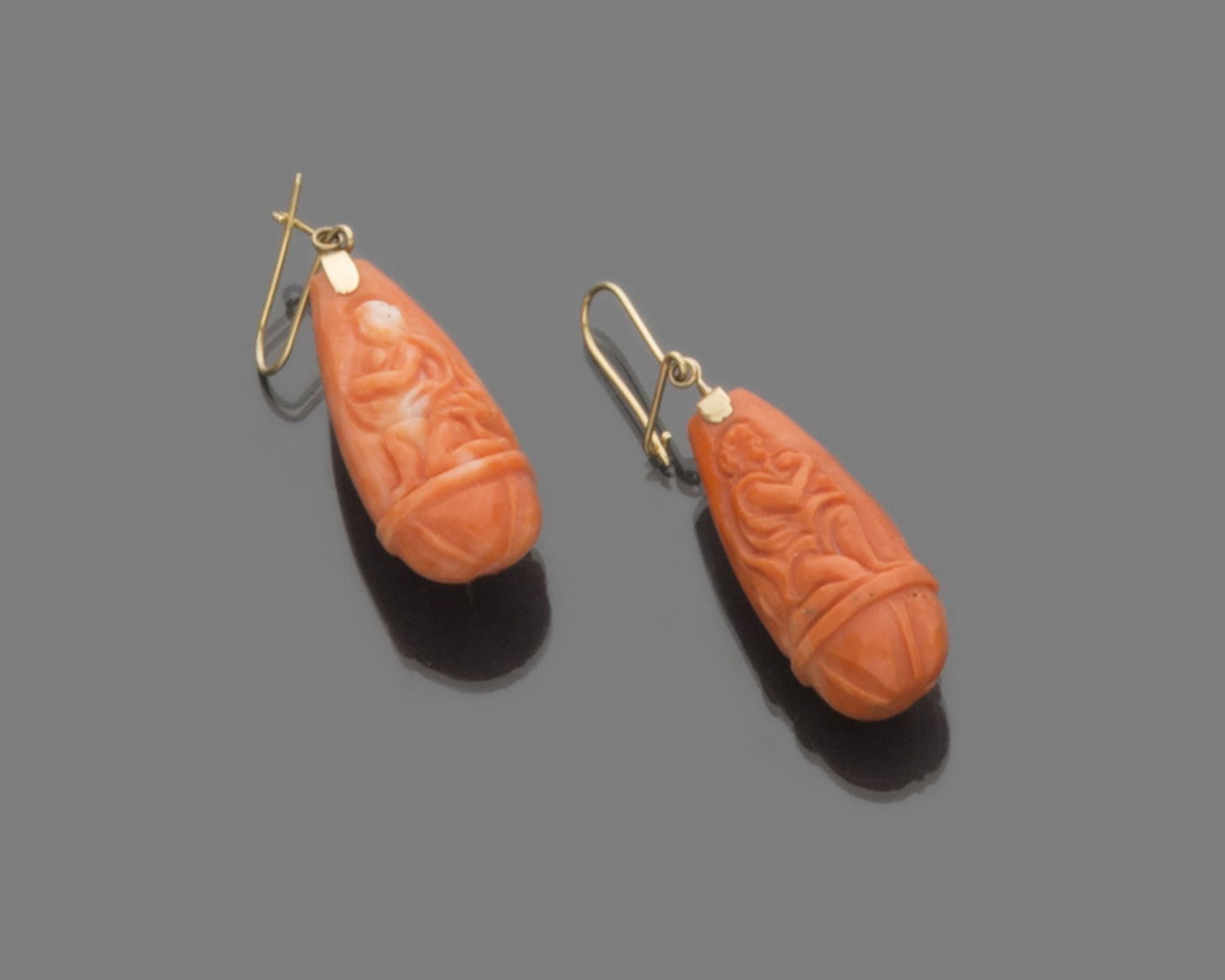 A PAIR OF EARRINGS in red coral of mythological figures in yellow gold 18 kts. Length cm. 5, total