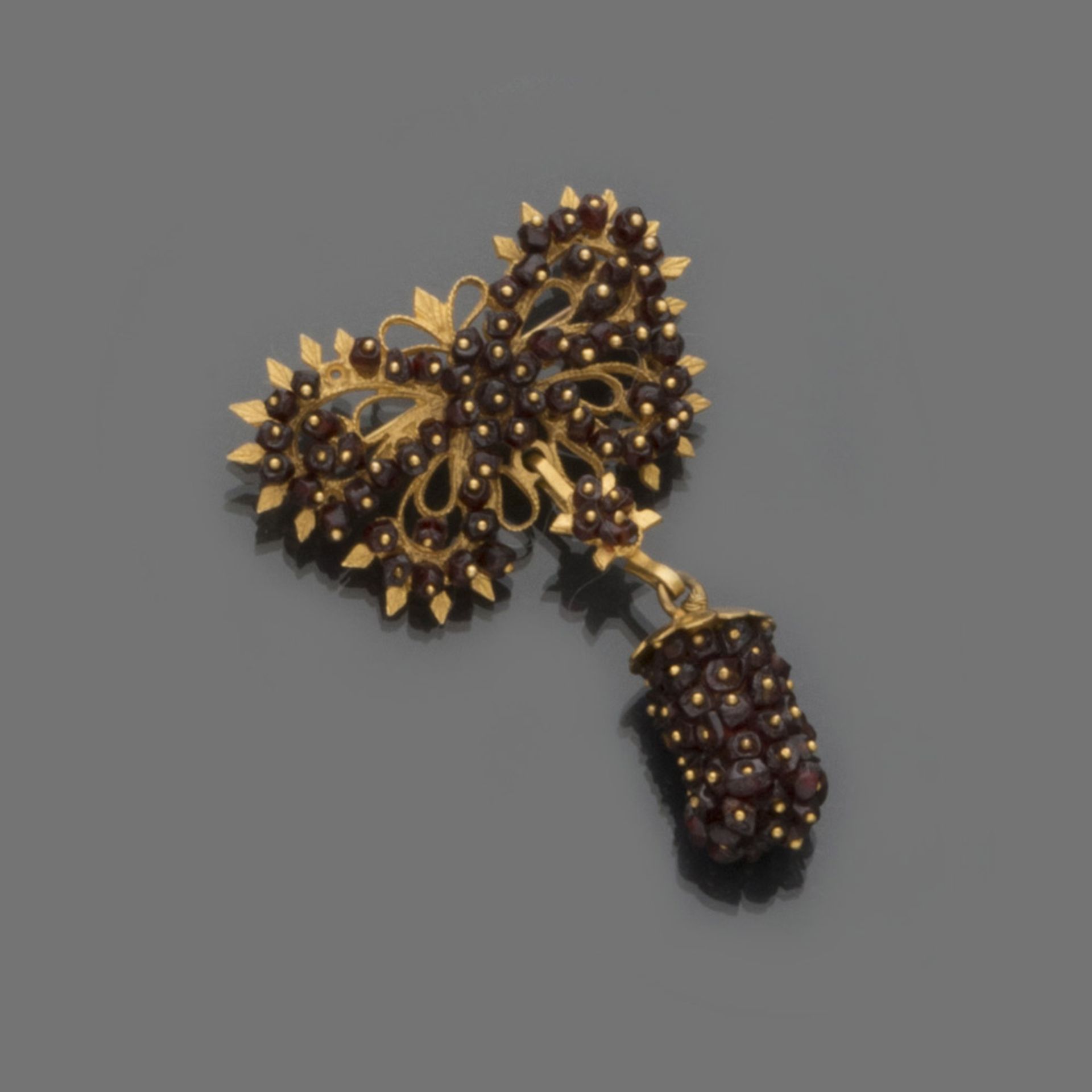BROOCH in yellow gold 18 kts., with decorum of pomegranates. Measures cm. 5 x 4, total weight gr.