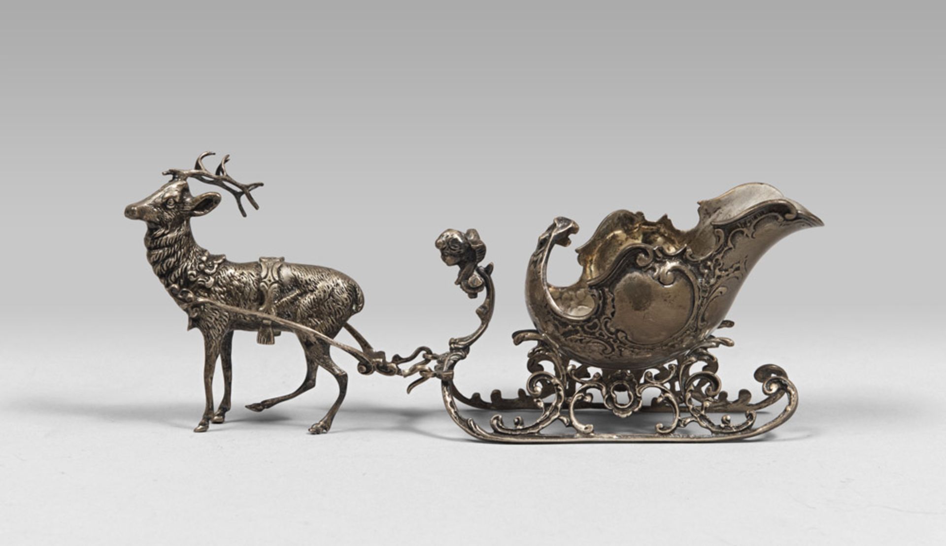 MODEL OF SILVERED METAL SLEIGH, 20TH CENTURY with coach carriage and figure of reindeer. Measures