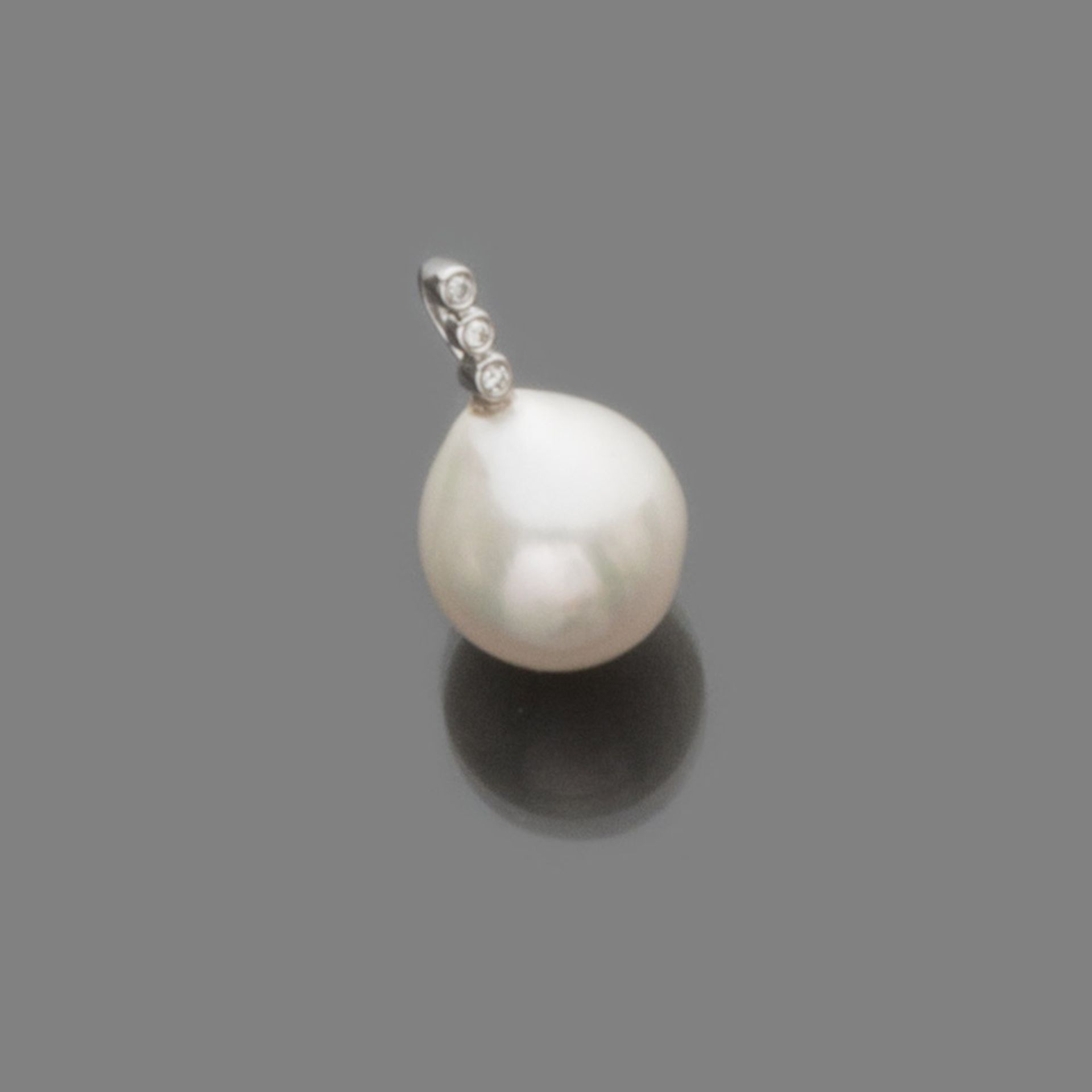 PENDANT in white gold 18 kts., with pearl surmounted by three small diamonds. Bright ct. 0.03, pearl