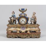 PORCELAIN CLOCK-TABLE, 19TH CENTURY in polychrome, with tower case, side by side with figures of