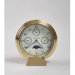 TABLE CLOCK, BRAND BUCHERER with circular brass case and dial with date and moon phase. Measurements