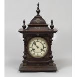 TABLE-CLOCK, 19TH CENTURY with walnut case and embossed metal leaf applications. White enamel