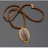 PENDANT in yellow gold 18 kt. and corniola, with oval shape on a brown silk cord with yellow