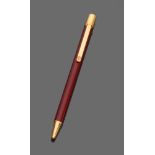 PEN CARTIER in red enamel metal with laminated yellow gold inserts. Length cm. 13. Complete with