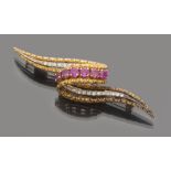 BROOCH in 18 kt yellow gold, with an abstract shape with the decoration of rubies and diamonds.