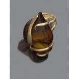 ANELLO in oro giallo 18 kt., a sagoma astratta con ambra decorata con elementi in oro. Peso