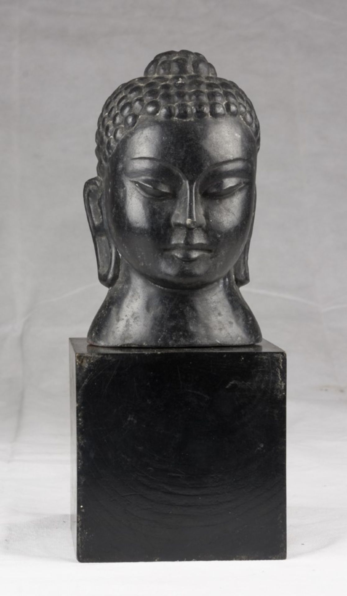 A Chinese stone head, depicting Buddha. 20th century. Measures cm. 20 x 12 x 12. TESTA IN PIETRA,