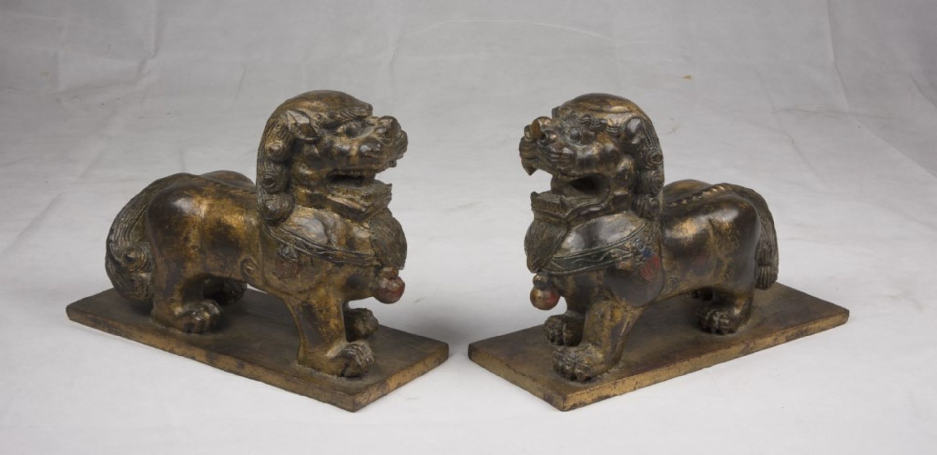 A pair of Chinese wood sculpture, depicting Buddhist lions. 20th century. Measures cm. 23,5 x 33 x