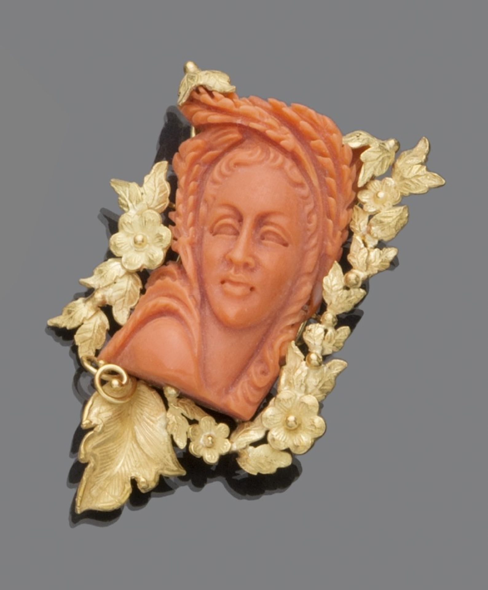 PRETTY BROOCH in 18 kt yellow gold, with floral motifs and coral carved with a female figure.