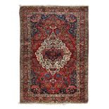 PERSIAN JOZAN CARPET, MID 20TH CENTURY with a flower medallion in white and secondary motifs with