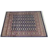 A modern Bokhara rug with blue ground and repeating medallion field, 190 by 140cm.