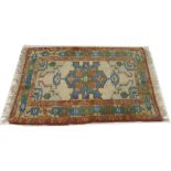 A Kazak hand knotted rug the central motif on a cream ground, 160 by 120cm.