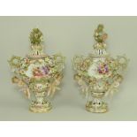A pair of Sitzendorf lidded vases, decorated in high relief with flowers and pair of putti,