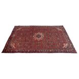 A Hamadan rug with red ground and detailed field, central cream pendant and small corners,