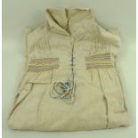 A hand embroidered shepherd's smock, linen sewn with coloured yarn.