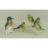 A Karl Ens figure group of blue tits, modelled as an adult with three chicks on a branch,