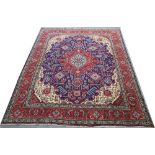 A Persian carpet with dark blue ground, central red medallion,