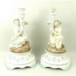 A pair of Dresden figural candlesticks, depicting classical maidens with conical holders,