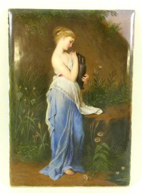 A German painted porcelain plaque of a young woman in Greco-Roman attire holding an amphora,