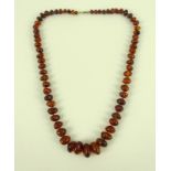 A vintage amber bead necklace, of clear treacle colour with some inclusions, 63cm long,