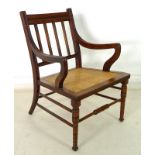 A late Victorian mahogany easy open armchair, line carved decoration, caned seat,