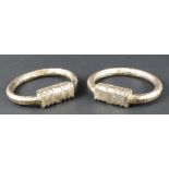 A pair of 19th century white metal Indo Persian rings, engraved overall with geometric detailing,