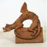 A modern cast terracotta roof ridge tile, modelled as a dragon with outswept wings,