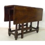 An early 19th century small oak drop leaf table, kick leg action,