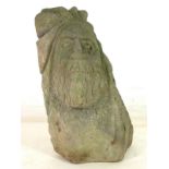 A stone fragment, carved with a bearded Green Man, 30 by 14 by 40cm high.