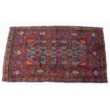 An Arak rug with dark blue ground, stylised floral patterned field with small red corners,