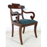 A William IV flame mahogany open armchair, with foliate carved rail, scroll carved arms,