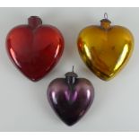 A set of three large vintage heart shaped foiled glass Christmas decorations, one red,