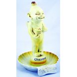 CHAIRMAN MATCHSTRIKER/ ASHTRAY FIGURE. 10.5ins tall, yellow glazed imp like figure stood on shell